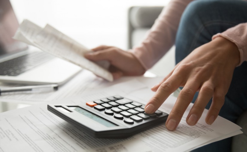 Woman,Using,Calculator,Holding,Paper,Bills,Calculating,Planning,Expenses,Money